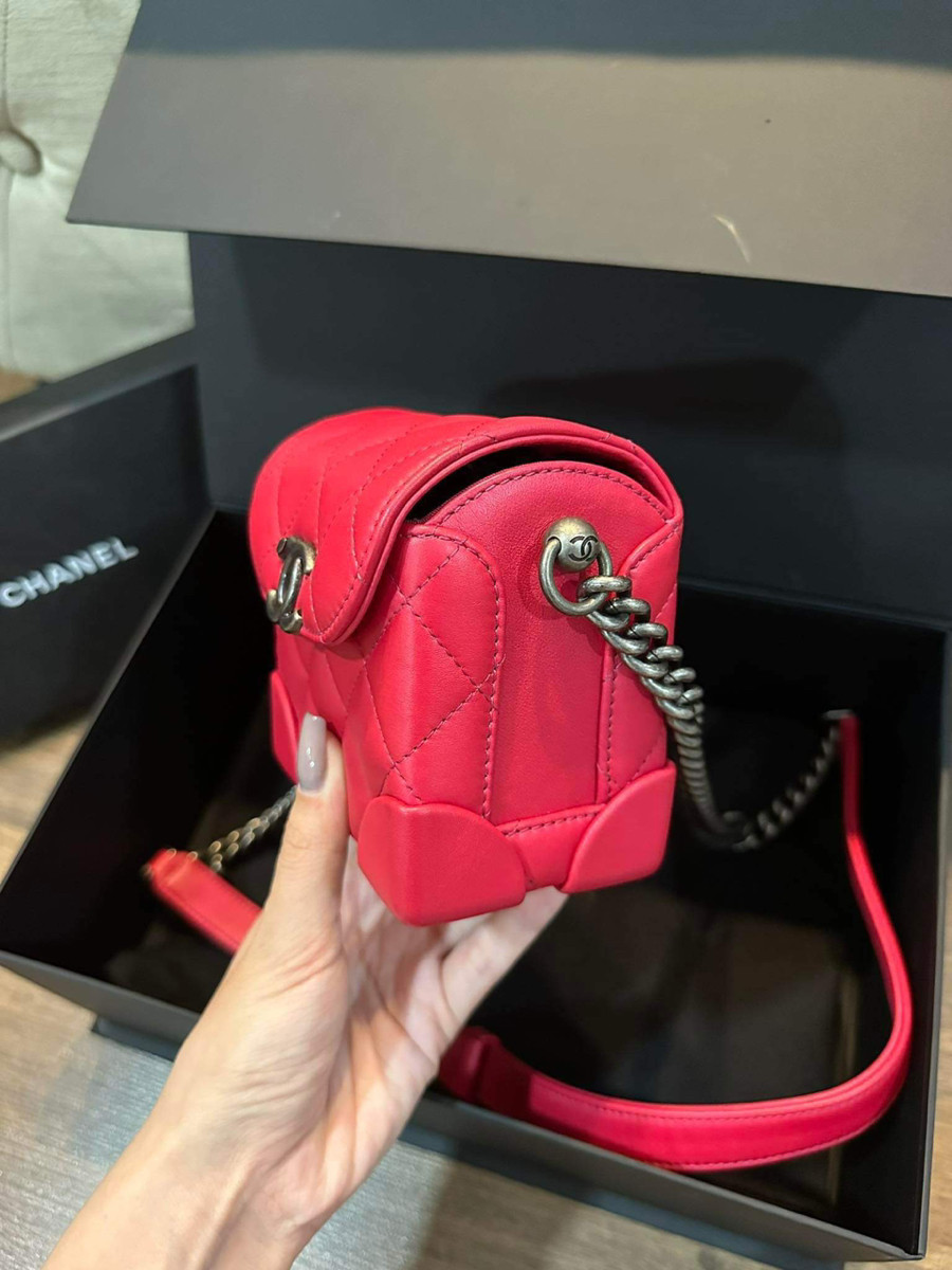 Chiếc túi Chanel màu đỏ hồng thiết kế điển hình của thương hiệu, logo  C nổi bật ở mặt trước, và dây xích màu ghi giả cổ.